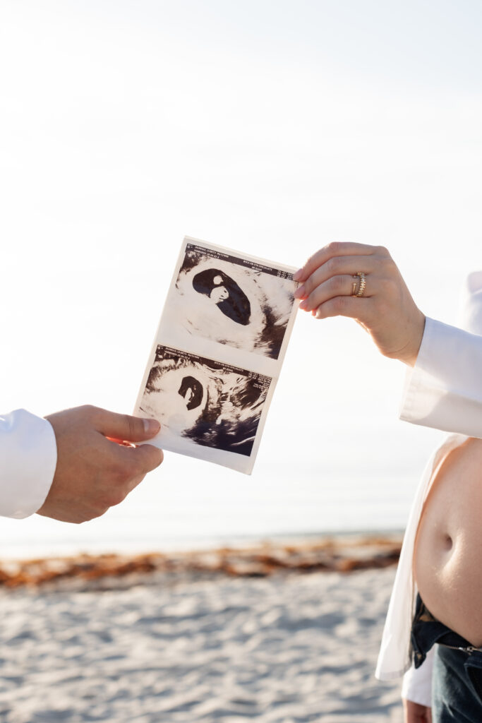 Expecting parents holding their baby’s sonogram during a Palm Beach maternity session