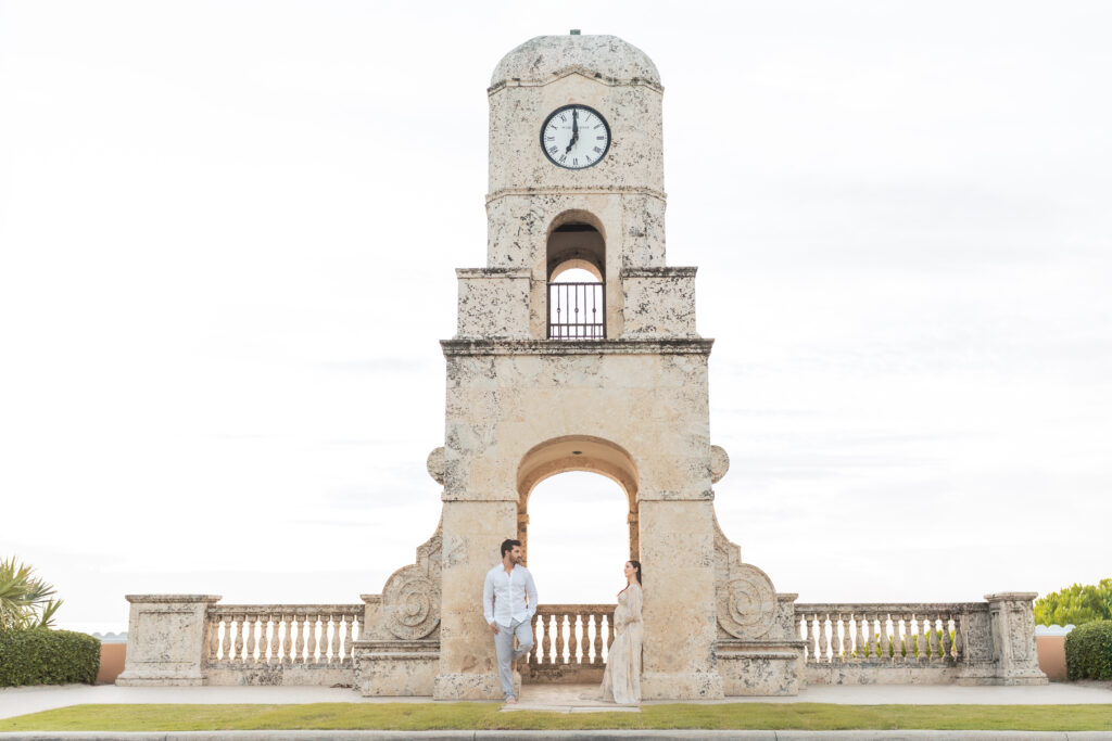Pregnant mother and partner posing near the iconic Palm Beach Clock Tower